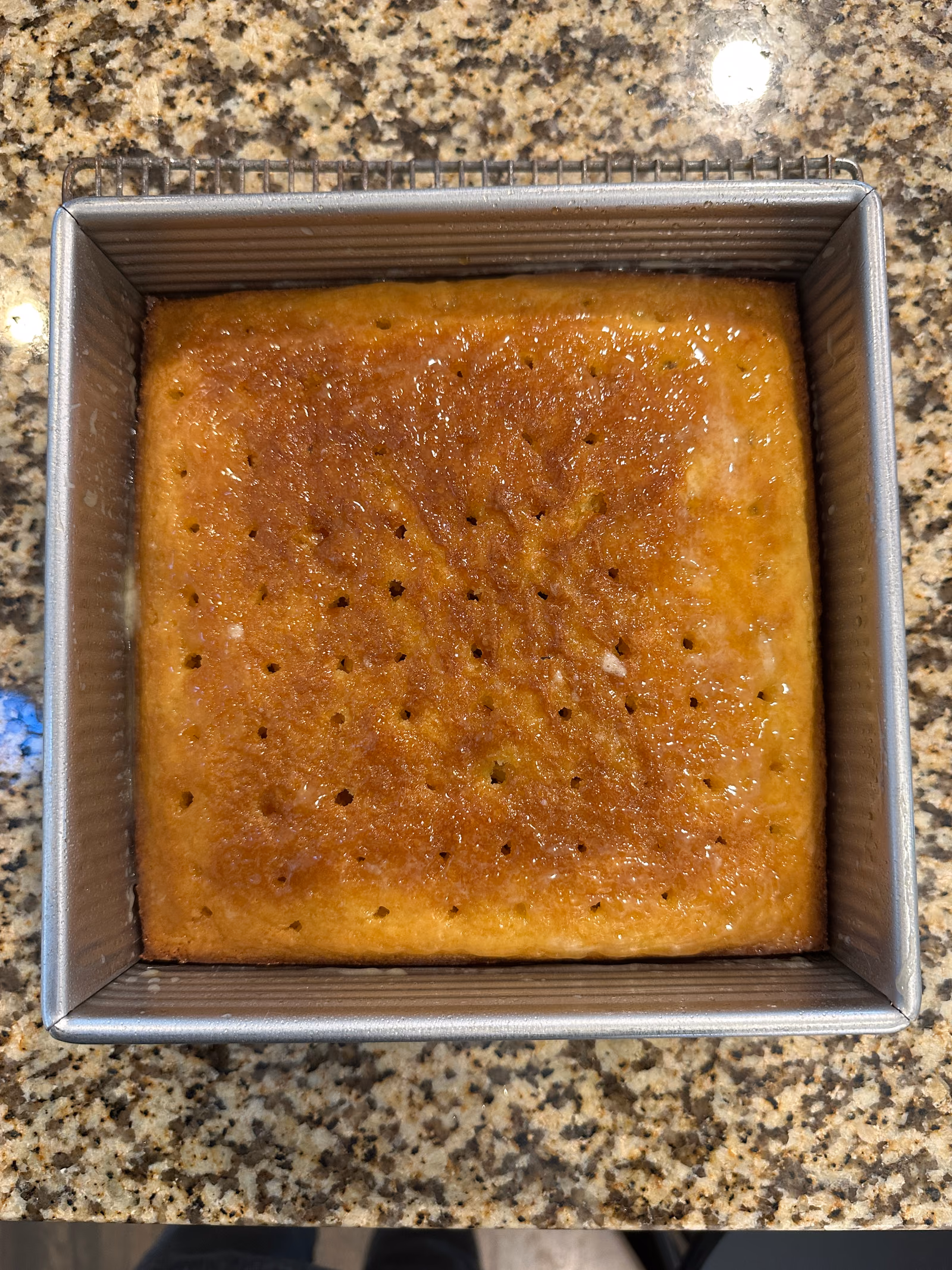 A baked malva pudding in a dish, its top caramelised to a deep golden brown.