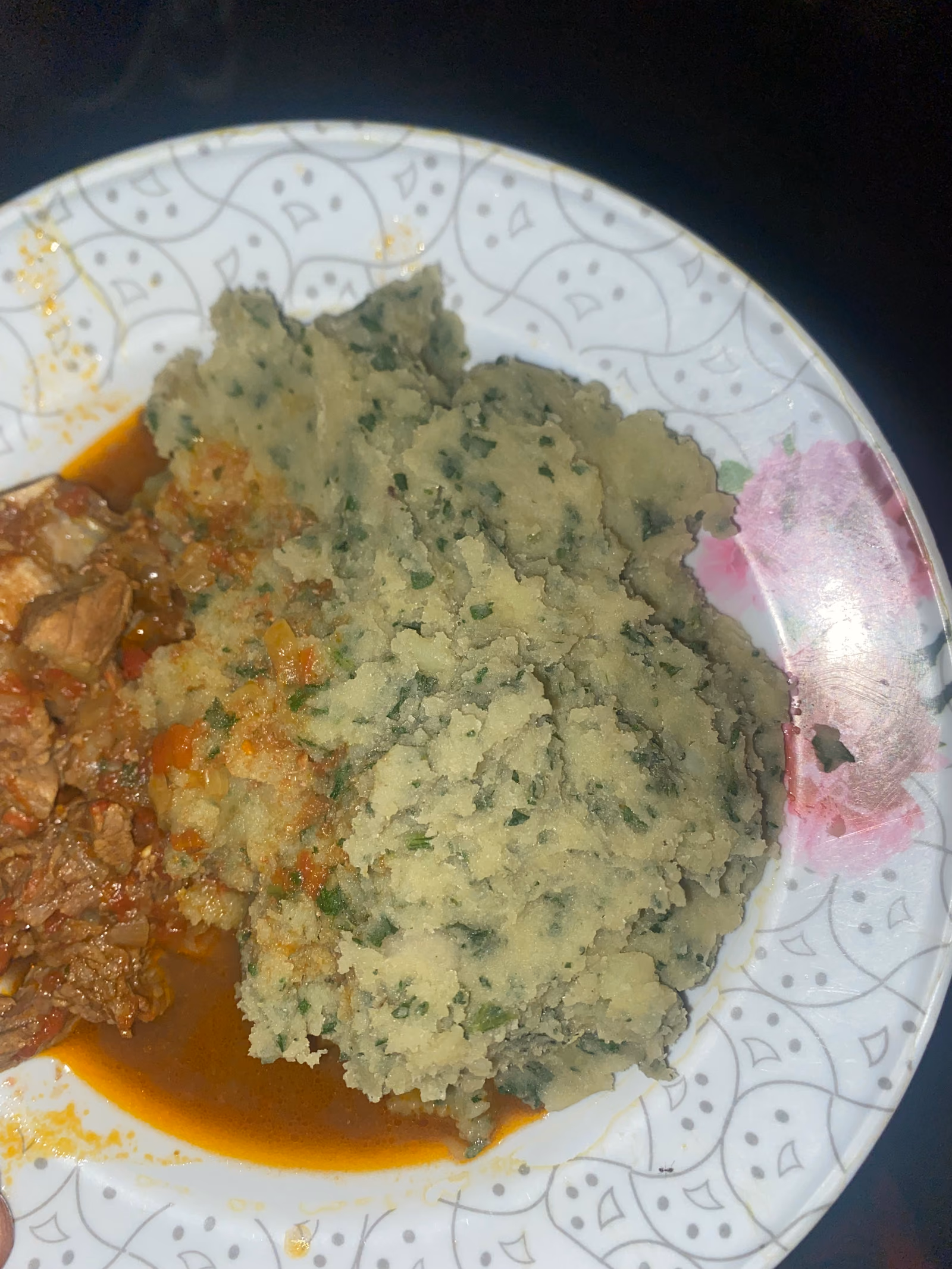 A bowl of bright green mukimo, mashed smooth and flecked through with maize and greens.