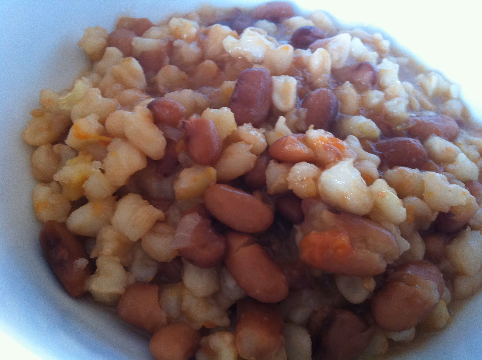 A bowl of umngqusho, swollen white samp kernels mixed evenly through soft brown sugar beans.