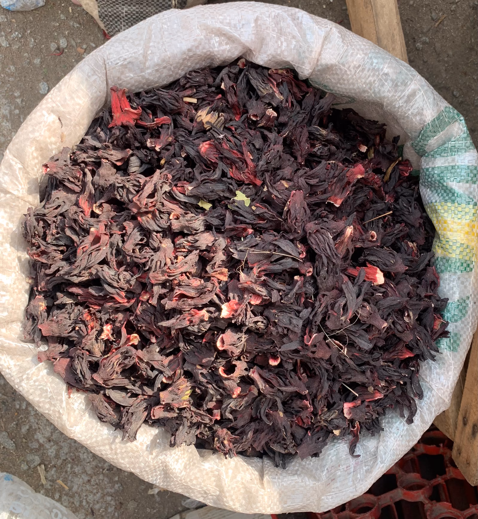 A heaped bag of dried deep-red hibiscus calyces, curled and papery.